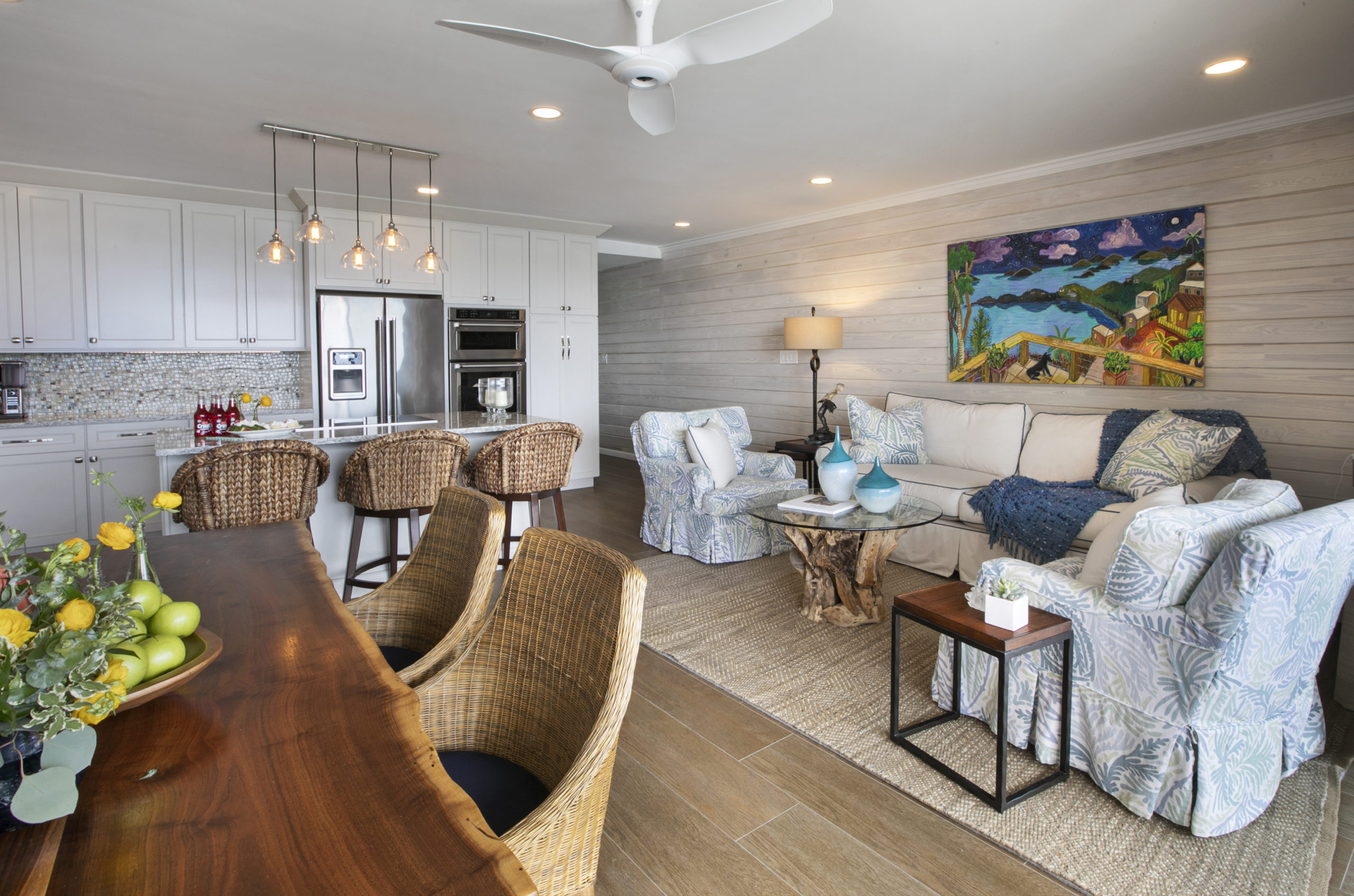 this small space condo kitchen offers 3 sets at the breakfast bar, a cozt lving room and a built in dining space. The accent wall in white washed cedar adds to the custom look of this condo remodel