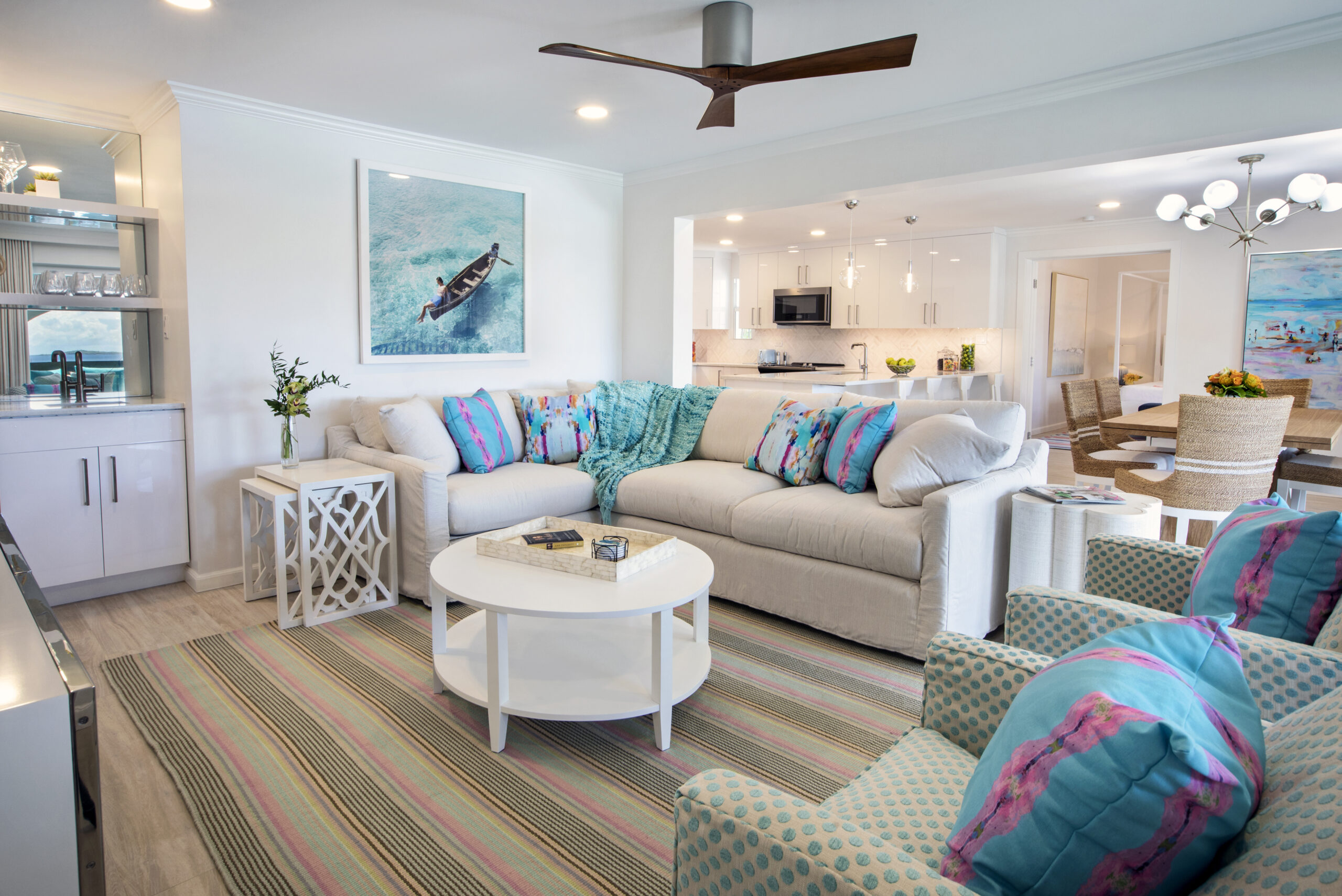 Livingroo with sectional sofa, wet bar for hospitality, striped rug and water color print pillows add the color