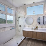 Double Vanity Bath with Waterfall show head and floating cabinetry with gorgeous views