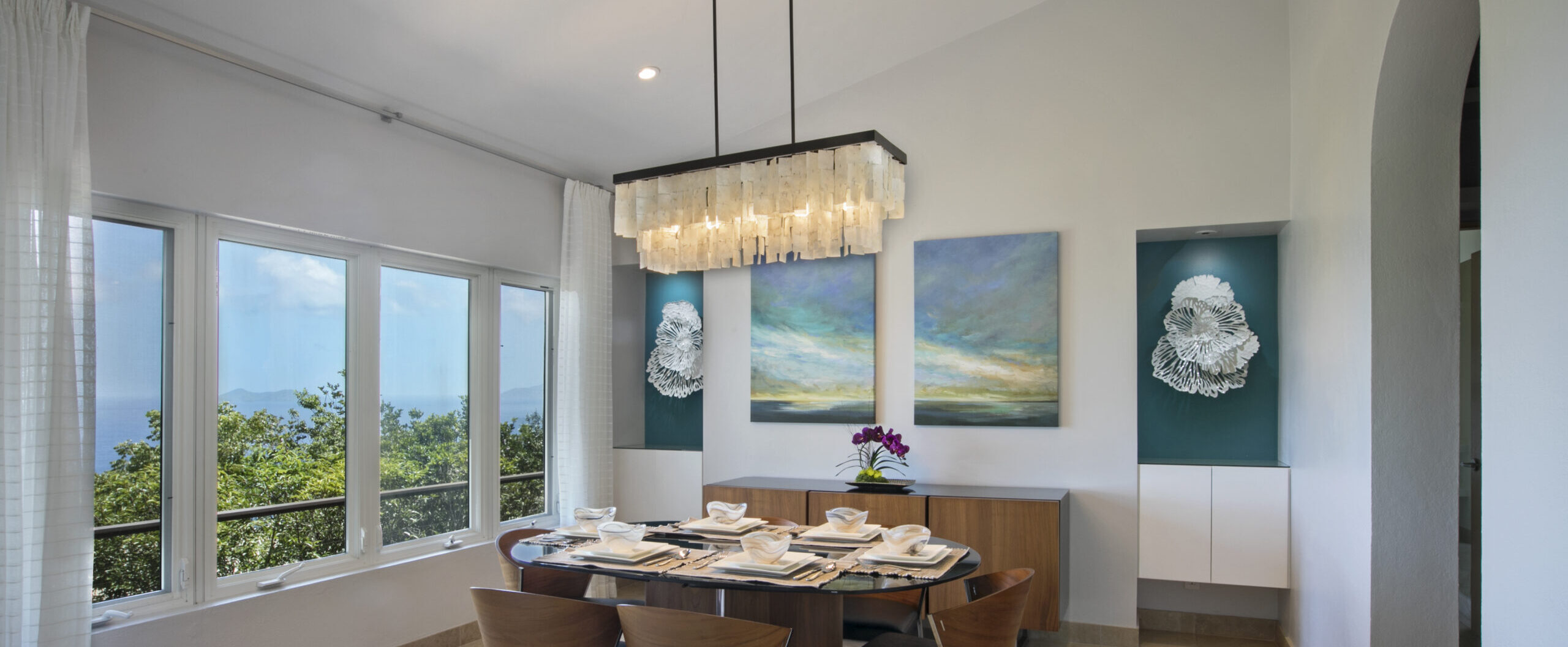 dining room design with chandelier and landscape artwork