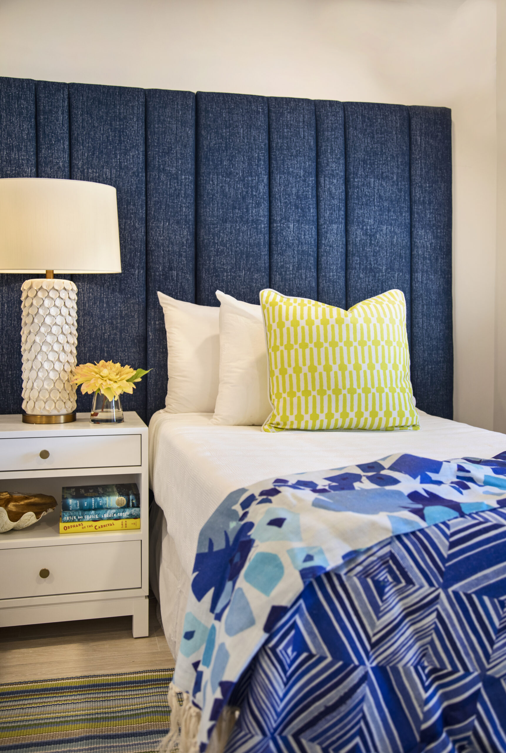 Island inspired bedroom design with a nightstand, lamp, and nautical headboard